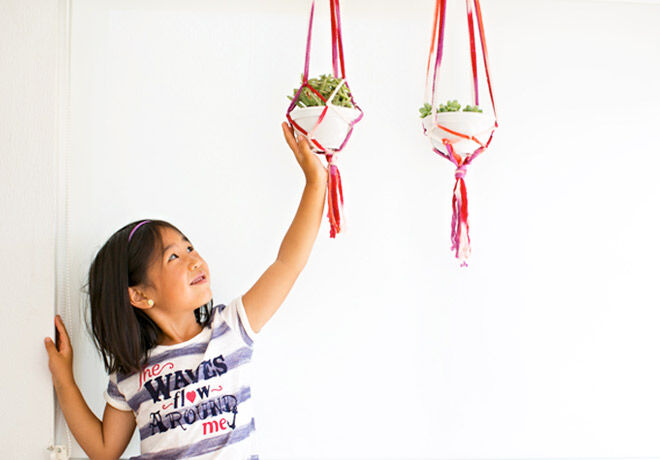 A little girl standing up handcrafted Macrame planters