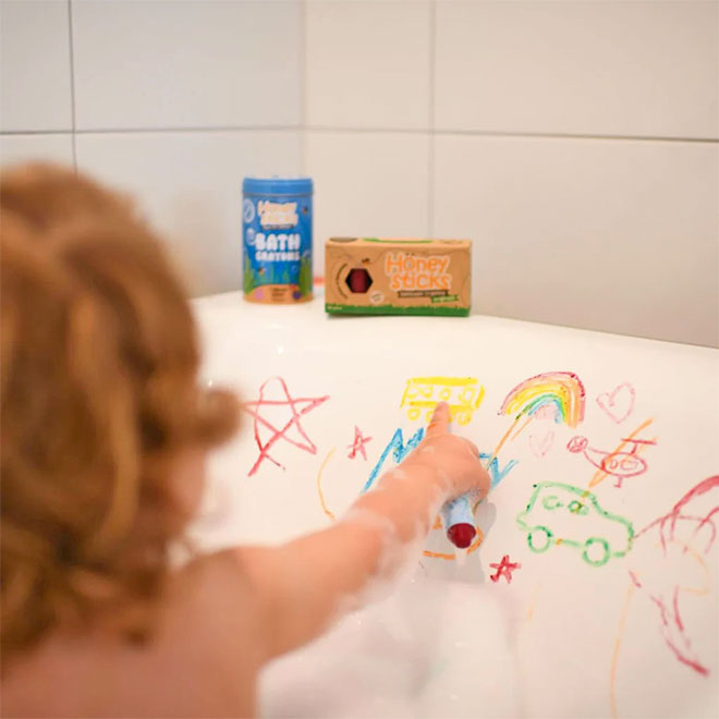 A child using Honeysticks Bath Crayons in the bath