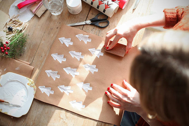 Stamp white Christmas trees on a brown paper background for the perfect homemade gift wrap