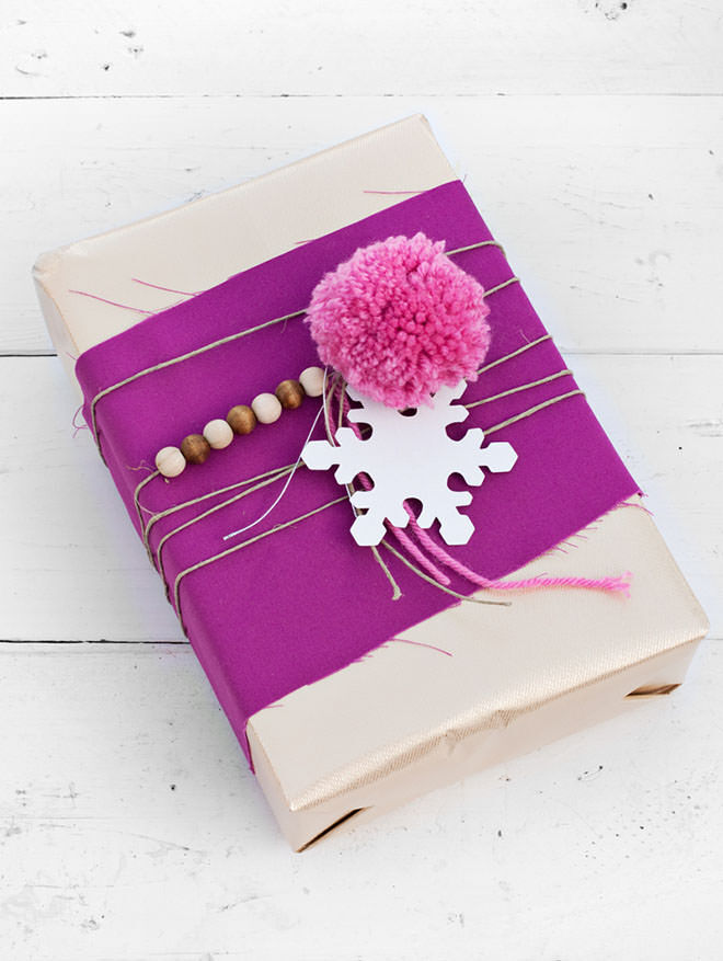 Gift wrapping with pom poms, string and fabric scraps