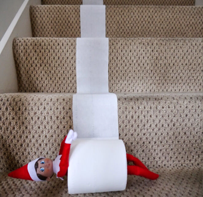 Elf on the Shelf takes a ride down the stairs in a toilet roll