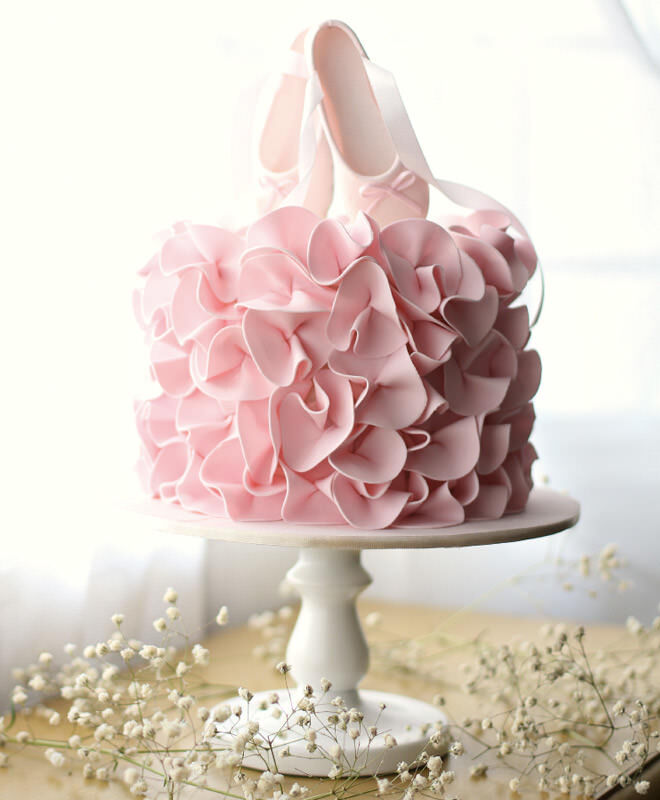 Ballerina birthday cake with pink ruffles and ballet shoe cake topper