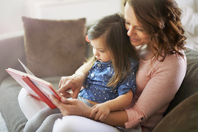 Mother helping daughter to read