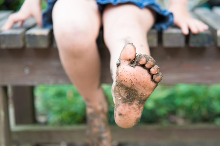 Nature play in the dirt with muddy feet