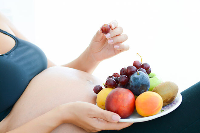 Pregnant belly eating fruit
