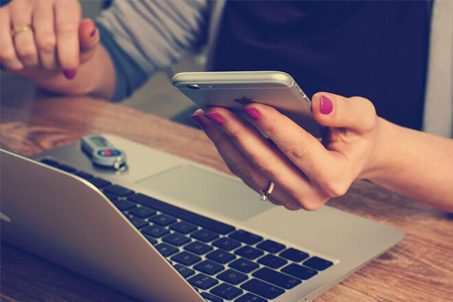 Lady on a computer and iPhone