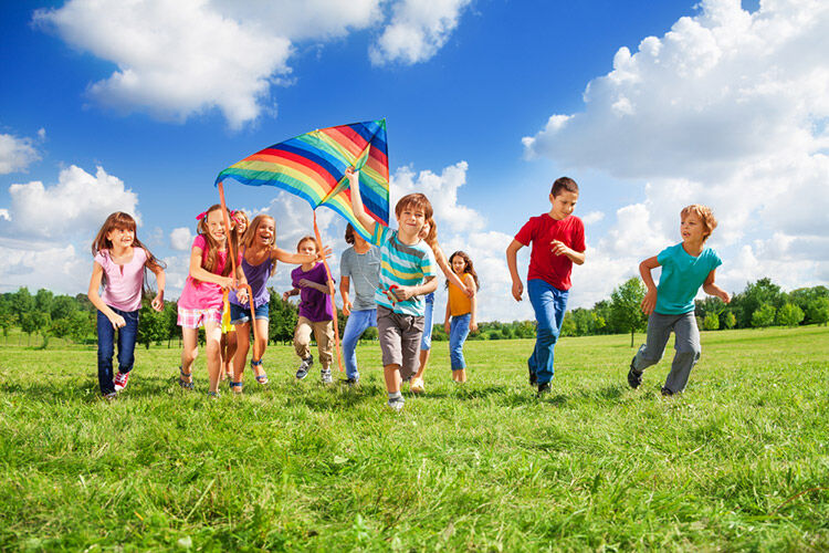 kids running and flying a kite