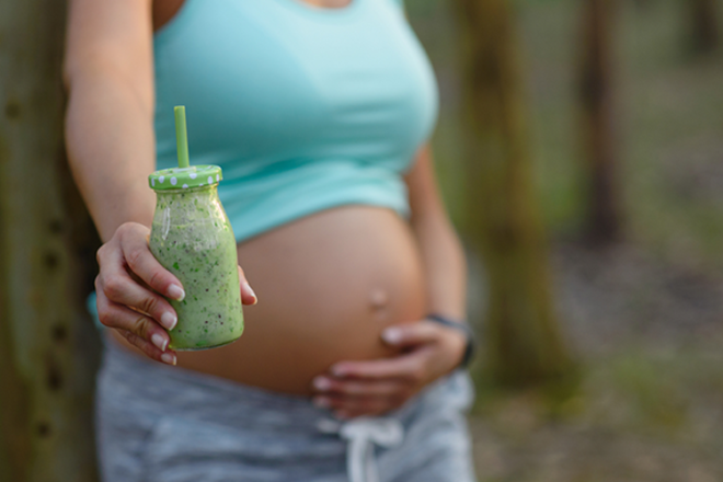 pregnancy smoothie: pregnant lady holding green smoothie