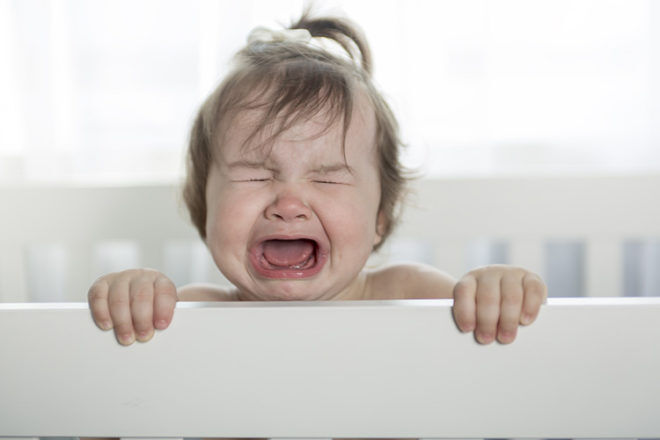 upset toddler in cot
