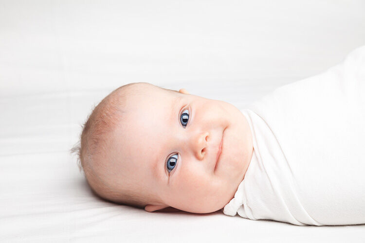 Baby wrapped in a white swaddle