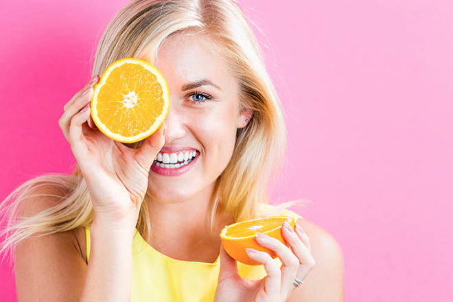 foods that boost fertility girl holding oranges