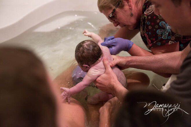 Mamarazzi Photography midwife assists in water birth