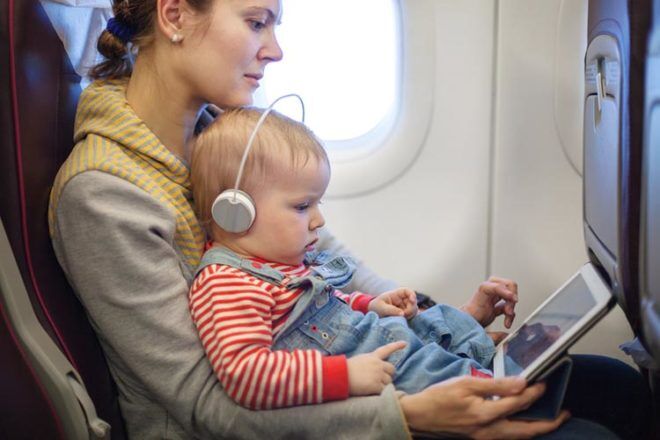 Baby sitting on mums lap on plane