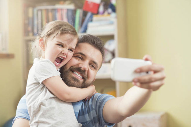 father poses for selfie with daughter stay-at-home dads do less work