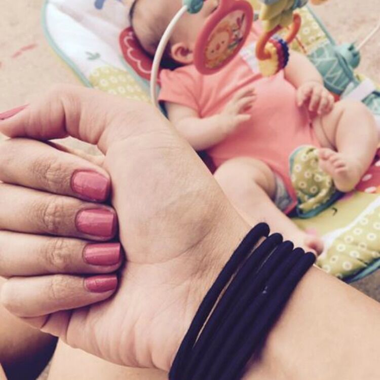 Five rubber hair bands on woman's wrist