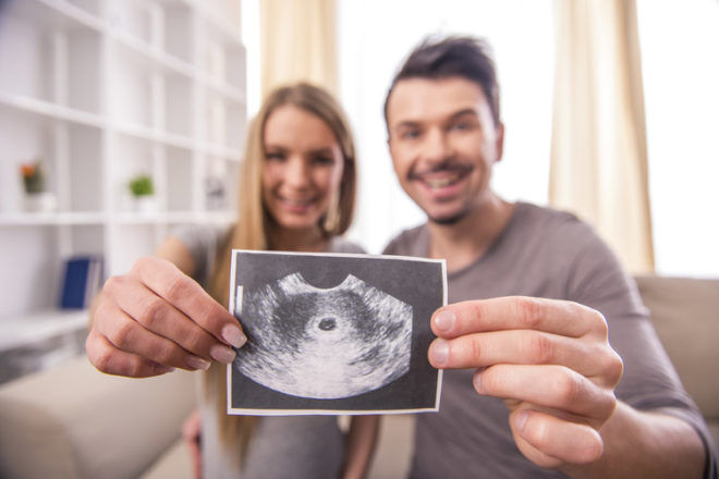 Young couple with their first baby ultrasound