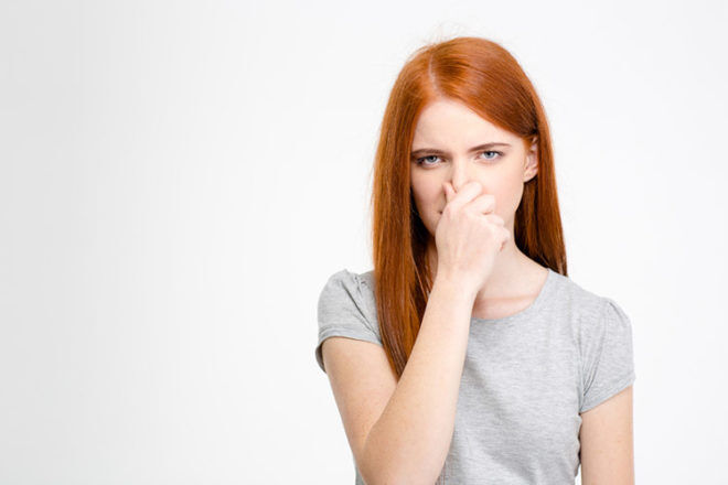 woman holding nose closed with a bad smell