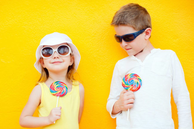 Kids with lolly pops on yellow background