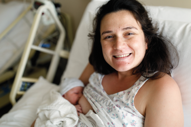 A happy new mother in hospital breastfeeding her newborn
