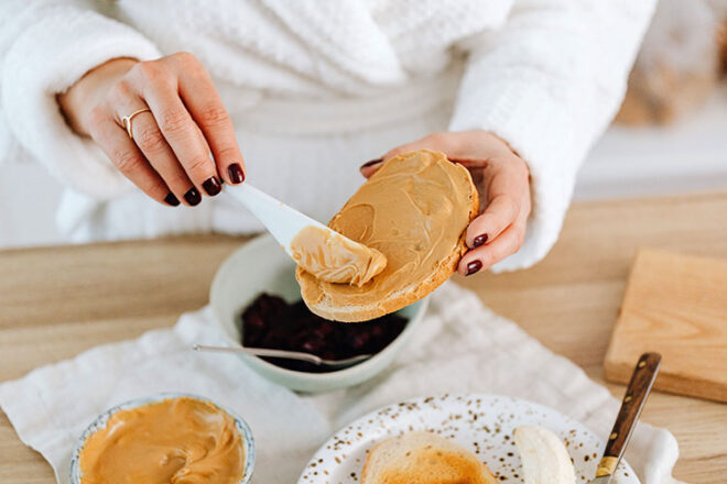 Women spreading peanut butter on toast