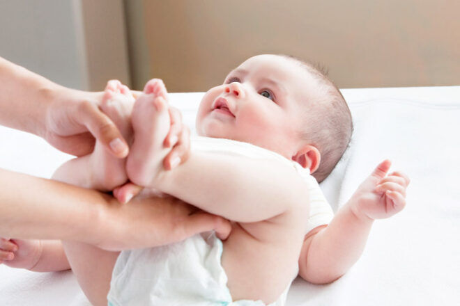 baby having nappy change feet holding