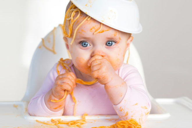 Little girl playing with food spaghetti