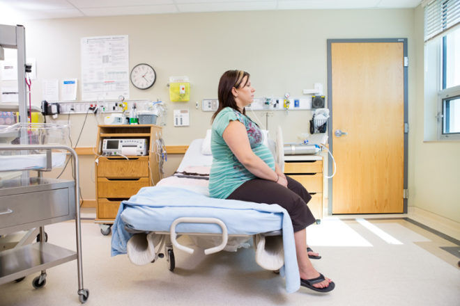 Pregnant lady sitting on hospital bed