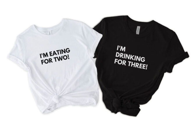 A white and black tshirt with the words 'I'm Eating for Two!' and 'I'm Drinking for Three!' written on the front