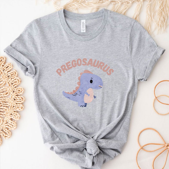 A grey tshirt with the words 'Pregosaurus' written on the front with a dinosaur