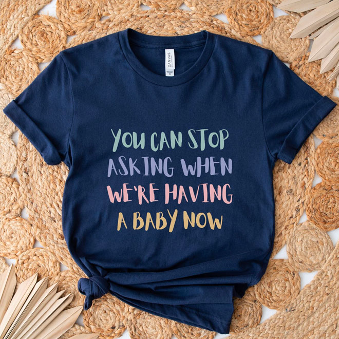 A navy tshirt with the words 'You Can Stop Asking When We're Having A Baby Now' written on the front