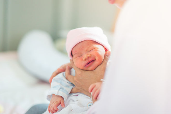 Newborn sitting on mums lap being burped