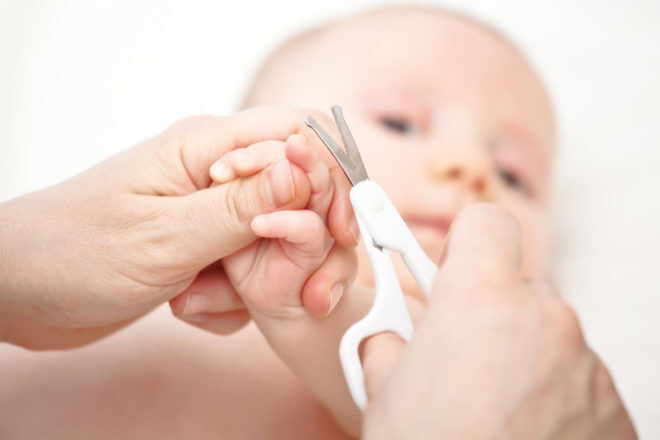 cutting newborn baby nails with scissors close Stock Photo - Alamy