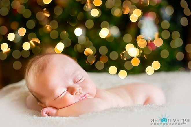 Baby's first Christmas photo asleep in front of the Christmas tree