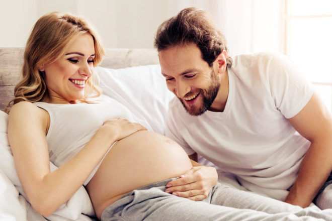 Husband talking to pregnant belly - baby can hear your voice during pregnancy