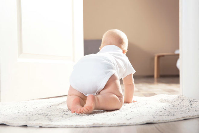 Put rugs over wooden and tiled floors as they may be too cold for baby