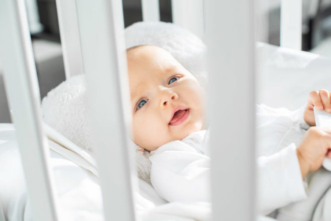 Baby in cot facing the sunlight