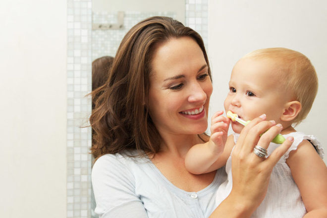 Mother brushing baby's teeth