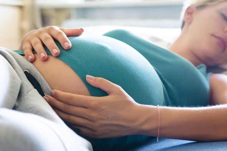 pregnant woman sleeping with hands on her belly