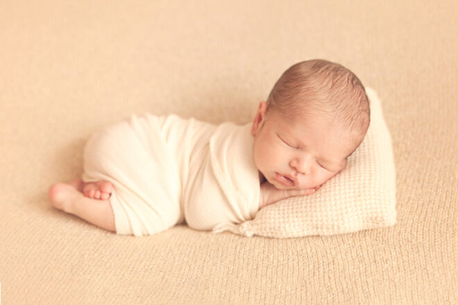 Portrait of newborn baby sleeping on a blanket and pillow