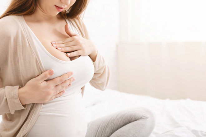 pregnant woman massaging breasts