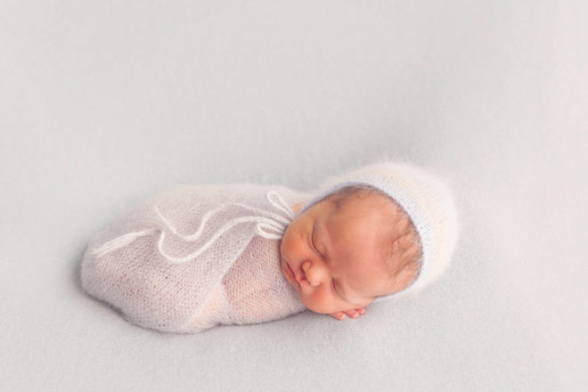 Newborn baby dressed in white