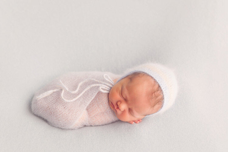 Newborn baby dressed in white