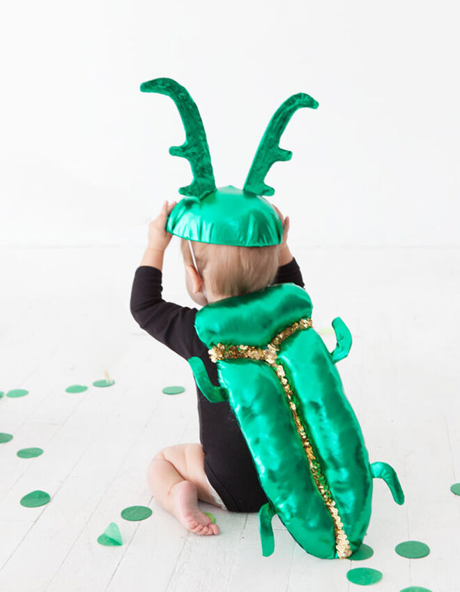Baby beetle costume worn by a toddler in black leotard for Halloween