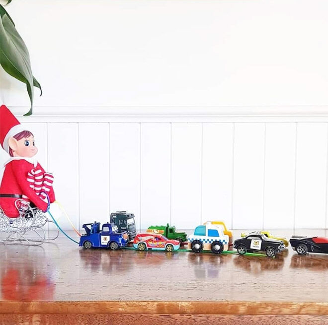 Elf on the Shelf pulling toy cars