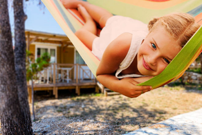 Girl in hammock outside holiday cabin