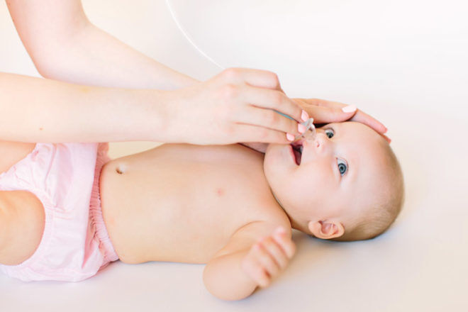 clearing baby's nose with a nasal aspirator