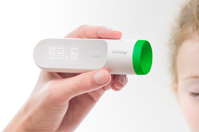 Withings Thermo Smart Thermometer australia being held in a mothers hand as she shows up the cool digital display of the temperature reading,