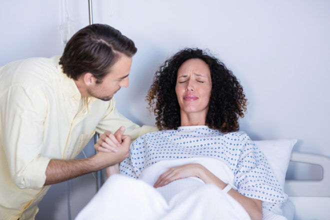 Husband comforting pregnant wife during labour