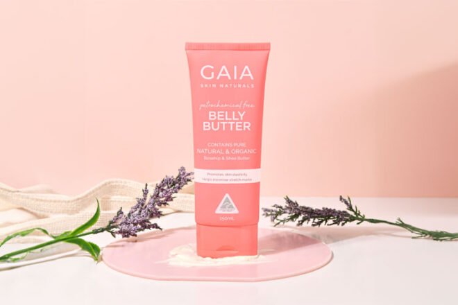 GAIA Belly Butter sitting in front of a pink background surrounded by lavendar