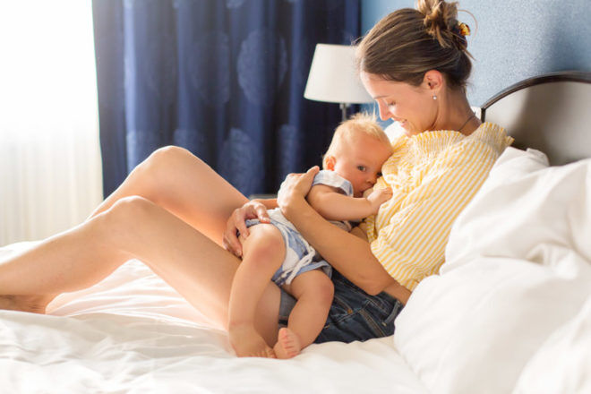 Woman breastfeeding toddler stk